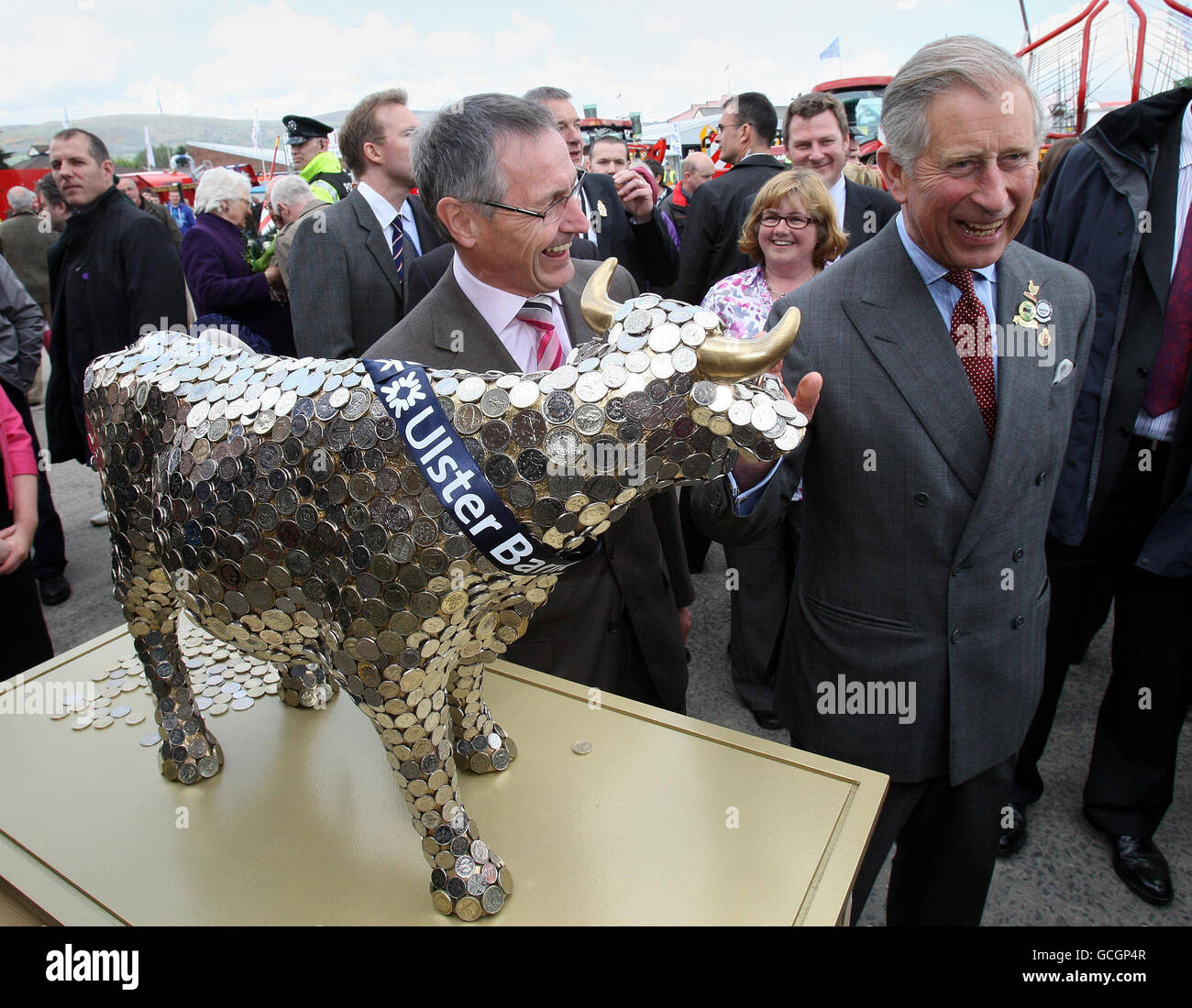 Il Principe del Galles con Henry Elvin (a sinistra), direttore della Ulster Bank, visita il cash cow stand di beneficenza, in aiuto del sostegno rurale mentre visita il Royal Ulster Agricultural Show (RUAS) presso la King's Hall nel sud di Belfast. Foto Stock