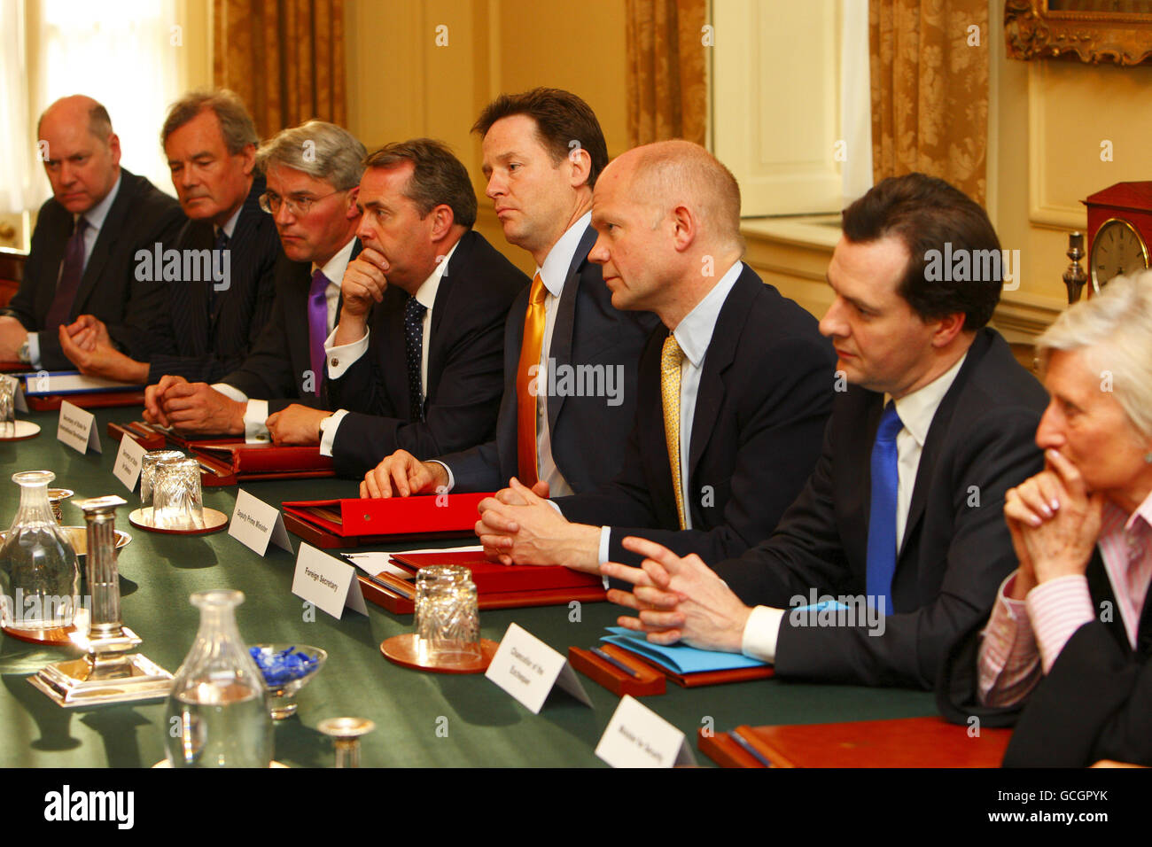 Il primo Ministro David Cameron (non mostrato) presiede la prima riunione del Consiglio di sicurezza Nazionale nella Sala del Gabinetto al 10 Downing Street. Tra gli altri presenti vi sono il vice primo ministro Nick Clegg (quinta destra), il segretario agli esteri William Hague (sesta destra), il cancelliere George Osborne (settima destra) e il segretario alla difesa Dr. Liam Fox (quarta destra). Foto Stock