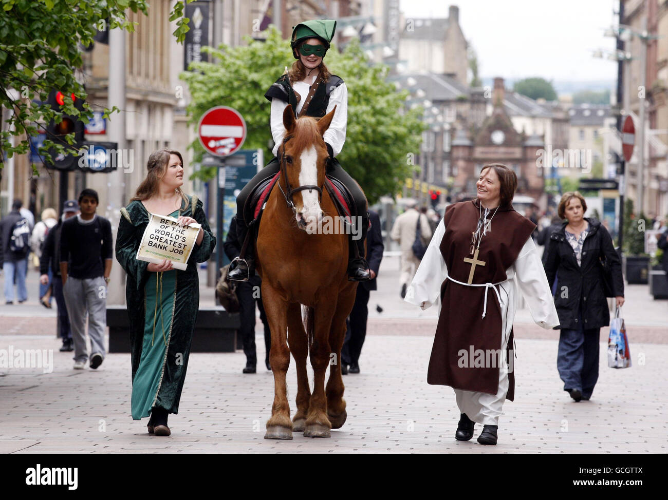 Sara Cowan Reynolds, attivista della lotta alla povertà di Oxfam, si vestì mentre Robin Hood cavalcava un cavallo lungo Buchanan Street a Glasgow, accompagnato da Kristin Reynolds vestita come Maid Marion per chiedere ai governi del G20 di sottoscrivere la Robin Hood Tax. Foto Stock