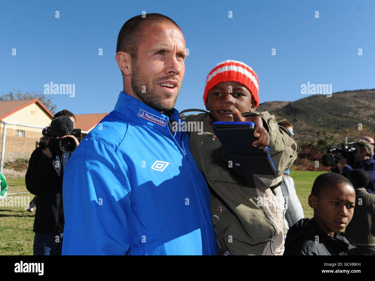 Calcio - Coppa del mondo FIFA Sud Africa 2010 - Inghilterra i giocatori visitano Local Township - Rustenburg. Matthew Upson di Inghilterra con Muzi di 3 anni durante una visita a Tlhabane Township vicino, Rustenburg, Sudafrica. Foto Stock