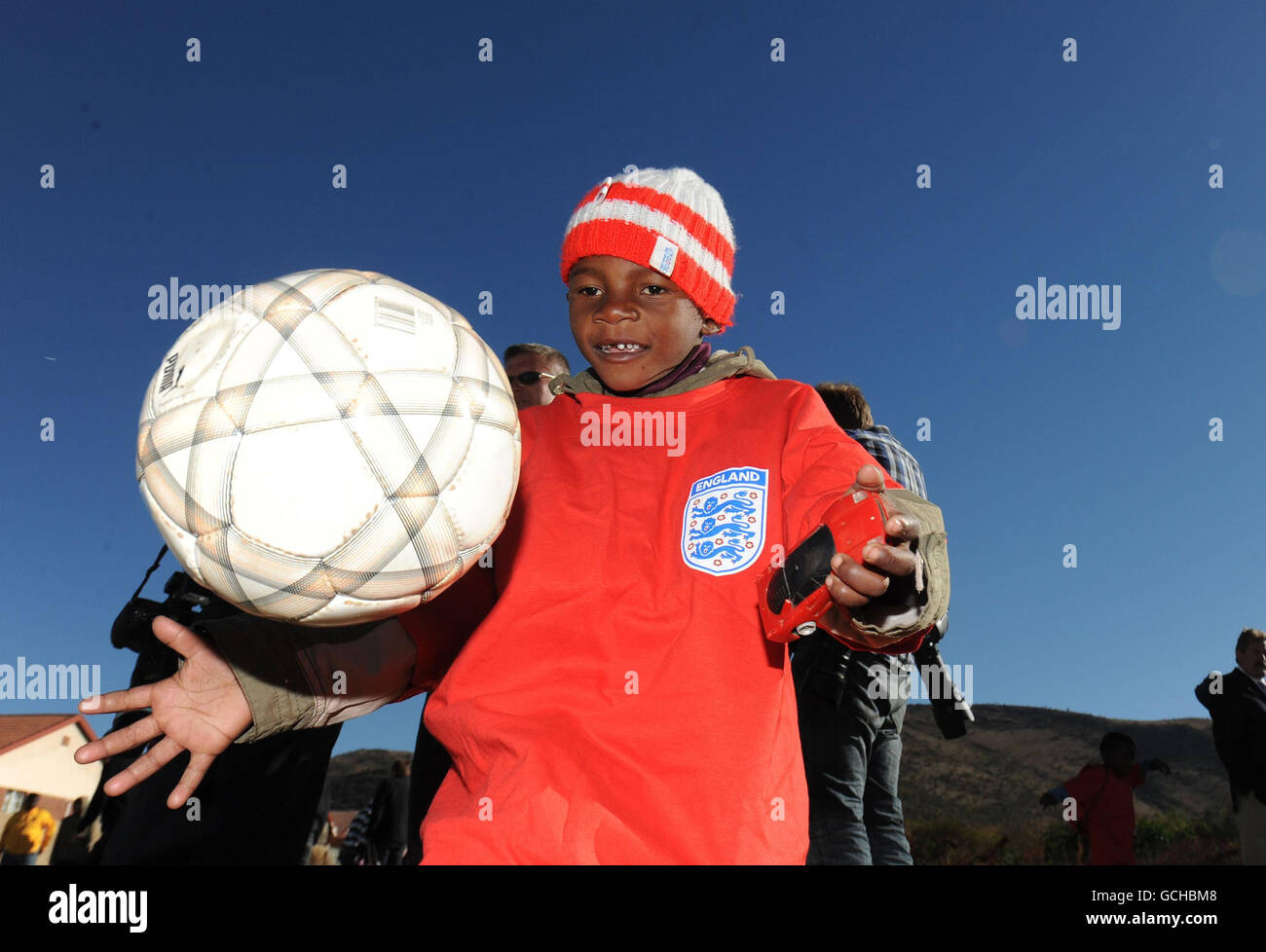 Calcio - Coppa del mondo FIFA Sud Africa 2010 - Inghilterra i giocatori visitano Local Township - Rustenburg. Johannes 5 tiene la palla in su dopo aver incontrato Michael Dawson e Matthew Upson che hanno visitato Tlhabane Township vicino, Rustenburg, Sudafrica. Foto Stock