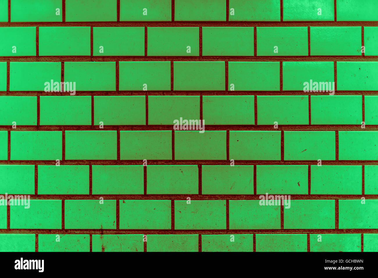 Sporco e granulosa di luce verde scuro rossiccio vintage verdolino città metropolitana piastrelle parete di stile con alcuni schizzi come punti di colore Foto Stock
