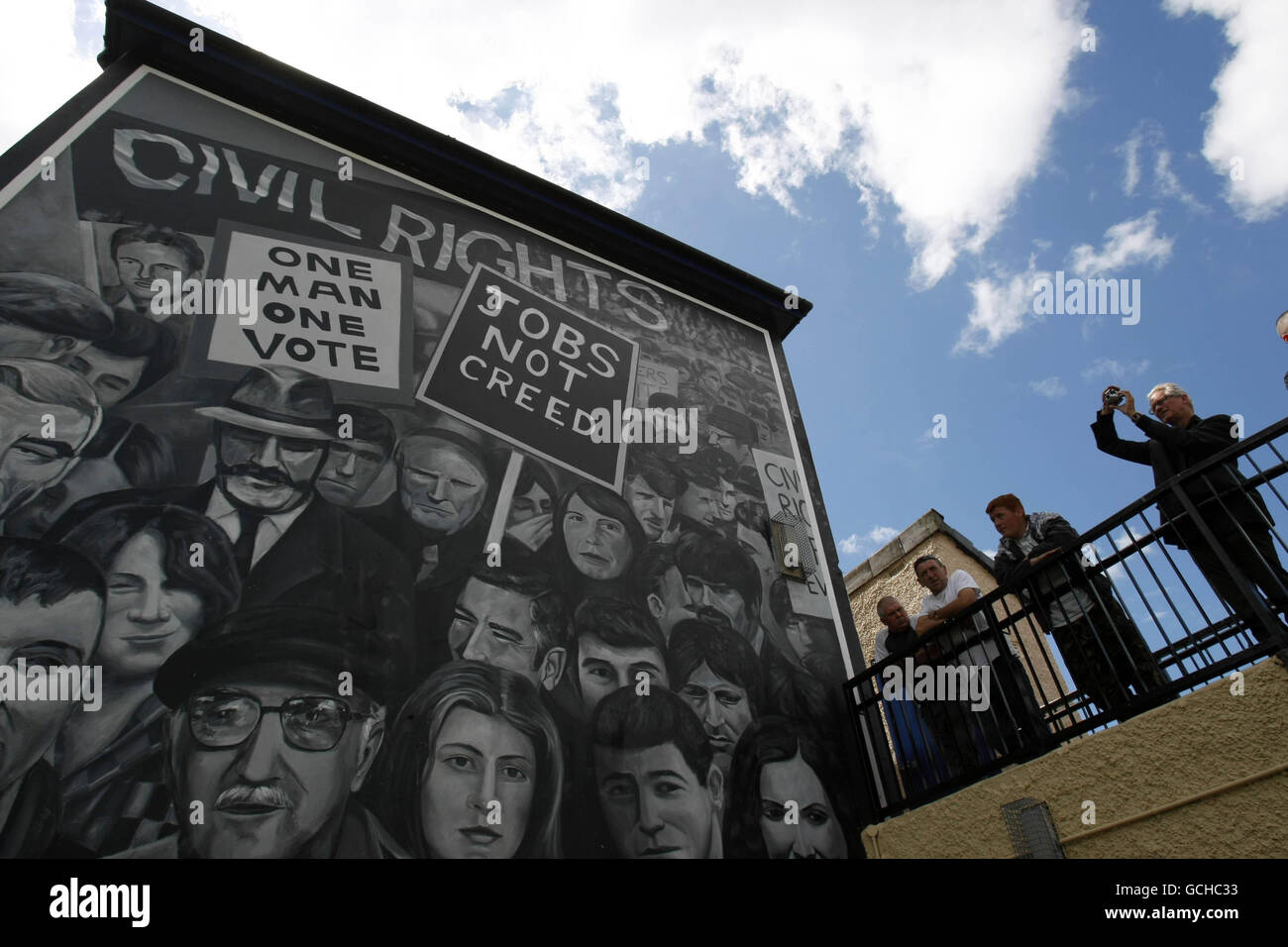 La gente scatta le foto di un murale della domenica di Bloody nella zona di Bogside di Londonderry, come una marcia dei parenti di coloro che sono morti fa il relativo senso alla Guildhall per la pubblicazione del rapporto d'inchiesta di Saville lungamente-atteso in Bloody Domenica. Foto Stock