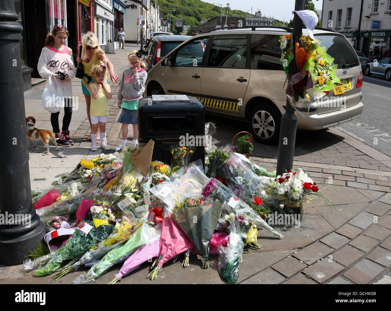 La gente guarda i fiori a sinistra al rango di taxi a Whitehaven dove Derrick Bird ha sparato e ucciso un tassista come è andato su una rampage di pistola uccidendo 12 persone. Foto Stock