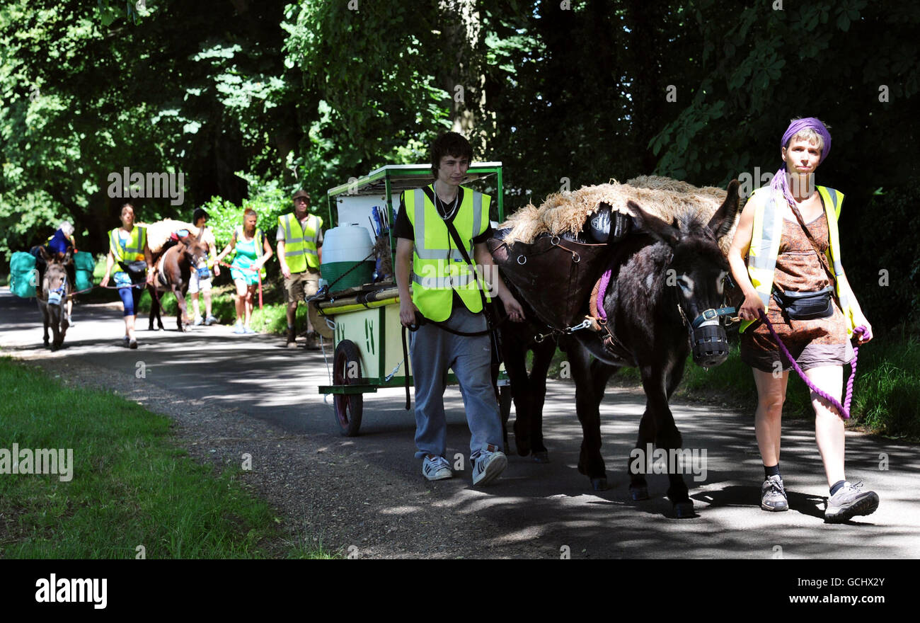 Sarah soffiatori (a destra), leader di un progetto chiamato come ho camminato fuori, conduce Merlin l'asino e il resto del gruppo su un trekking di 400 miglia attraverso il Gloucestershire rurale che non lascerà alcuna impronta ecologica perché hanno asini 'carbonio neutro' per trasportare le disposizioni e un pannello solare. Foto Stock