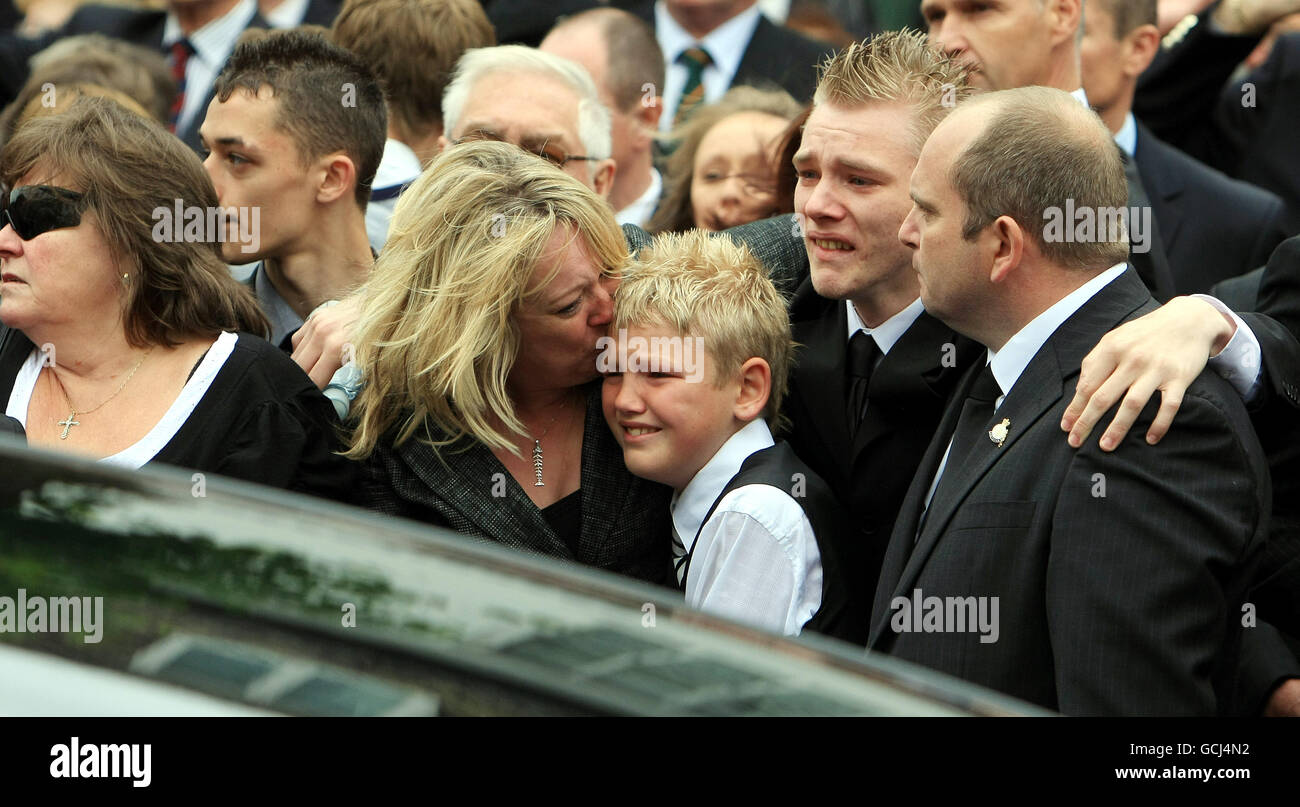 Nicola Hotine (centro), madre di Marine Anthony Hotine, 21 anni, bacia suo figlio Callum. La bara di Marine Hotine passa attraverso Wootton Bassett insieme alle barline del Corporal Terry Webster, 24, Lance Corporal Alan Cochran, 23, e Lance Bombardier Mark Chandler, 32, dopo che i loro corpi sono stati rimpatriati a RAF Lyneham, Wiltshire. PREMERE ASSOCIAZIONE foto. Data immagine: Giovedì 10 giugno 2010. Come è ormai tradizione, centinaia di membri della Legione Britannica reale, soldati e benestanti hanno costeggiato la strada accanto alle famiglie dei soldati caduti per rendere omaggio agli uomini. Vedere DIFESA storia PA Foto Stock