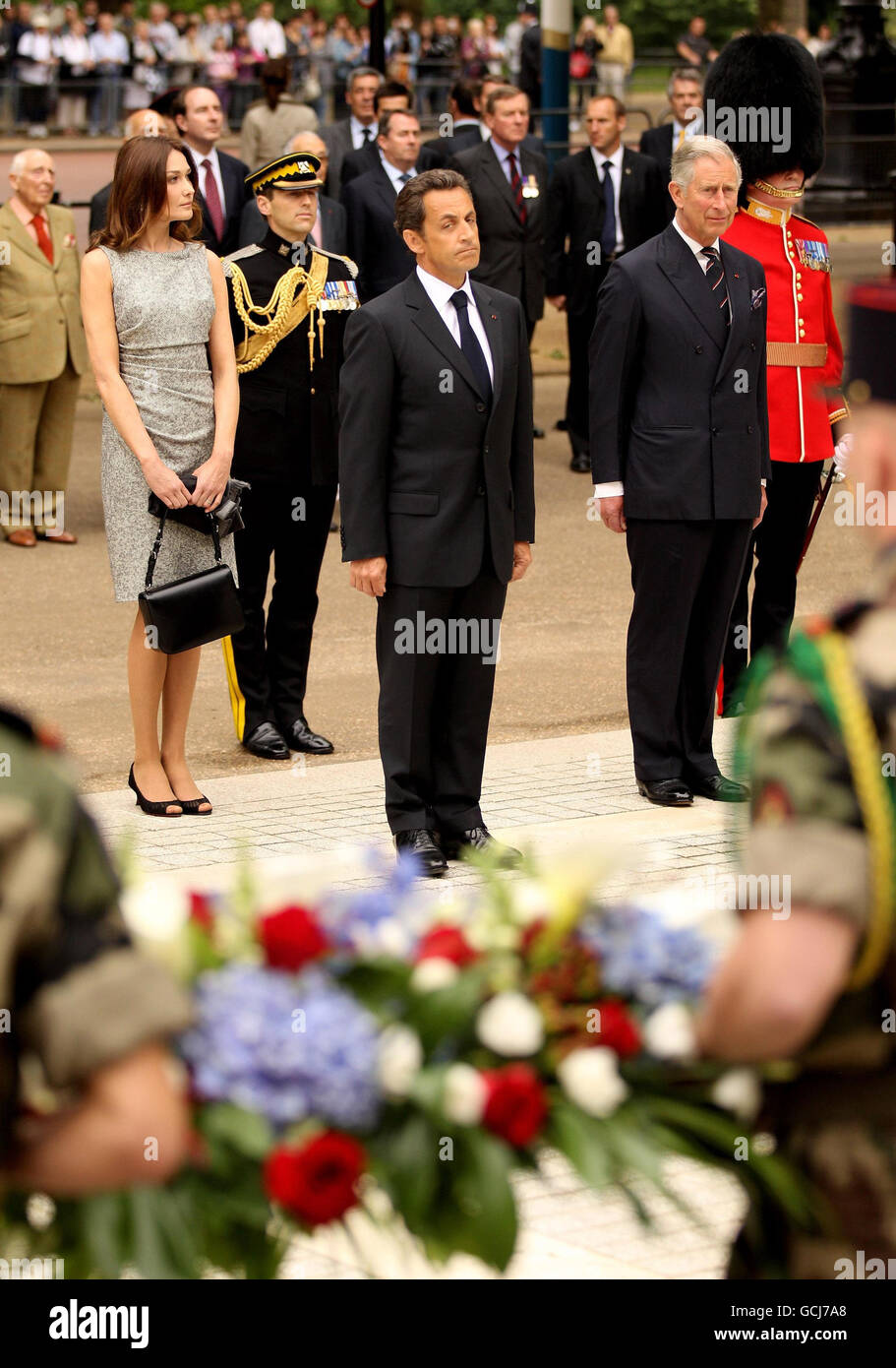 Il Principe del Galles (a destra) il Presidente francese Nicolas Sarkozy (al centro) e sua moglie Carla Bruni si preparano a deporre una corona alle statue di re Giorgio VI e regina Elisabetta sul centro commerciale di Londra. Foto Stock