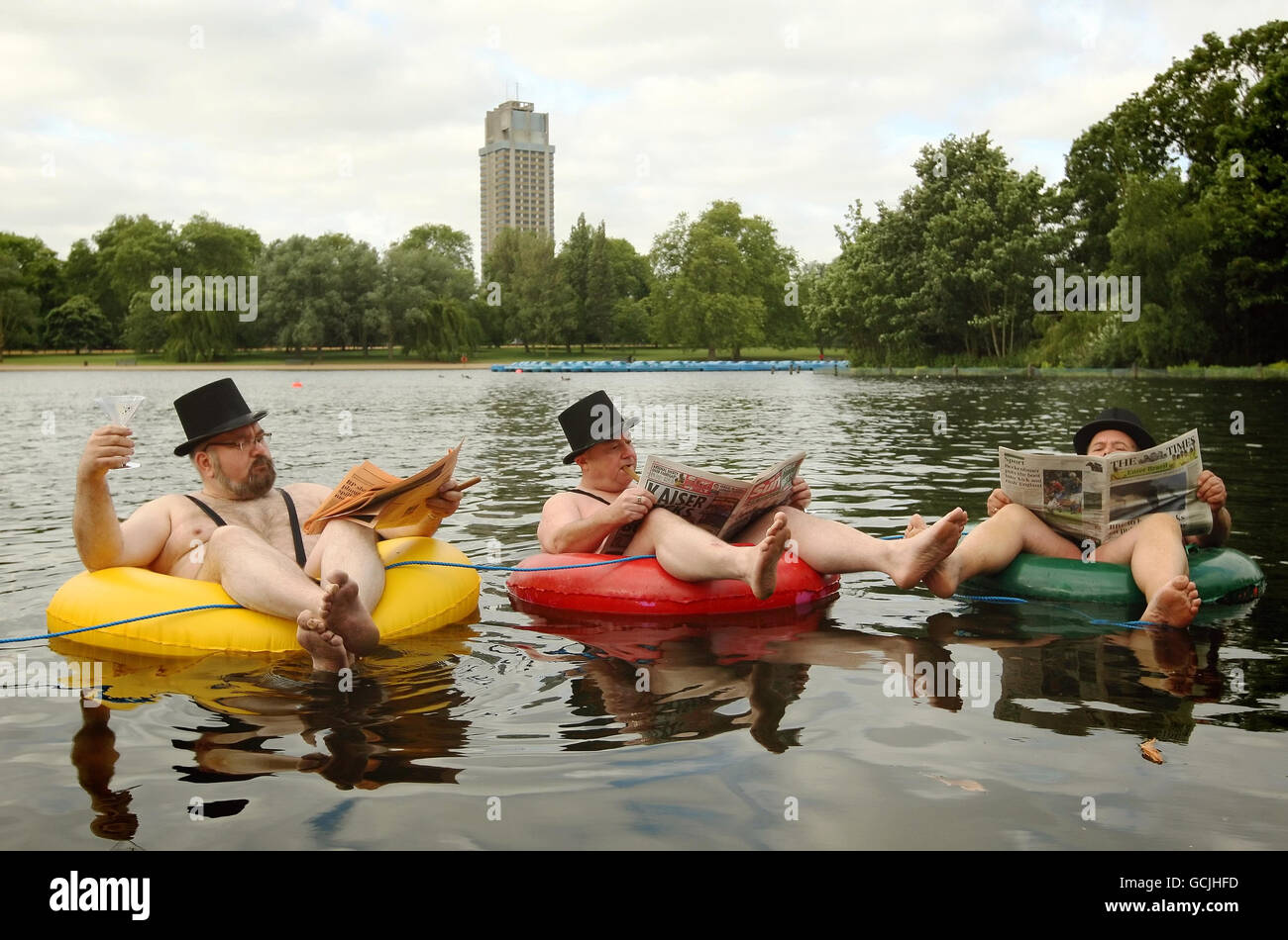 Uomini d'affari vestiti in mankini galleggiano su anelli di gomma sulla serpentina a Hyde Park, nel centro di Londra, durante una fotocellula per la nuova società di telefonia mobile 'a guida di comunità' giffgaff. Foto Stock