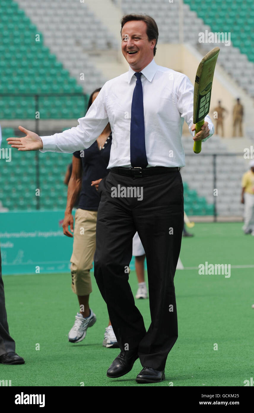 Il primo ministro David Cameron gioca a cricket con i bambini delle scuole locali al Major Dhyan Chand National Hockey Stadium di Delhi, l'ultimo giorno di una gita di tre giorni in India. Foto Stock