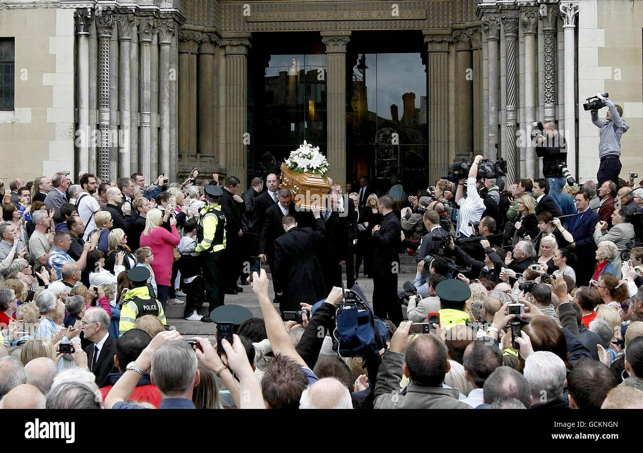La folla guarda avanti mentre la bara di Alex Higgins viene portata dalla cattedrale di St Anne, Belfast, dove ha avuto luogo il suo servizio funerario. Foto Stock