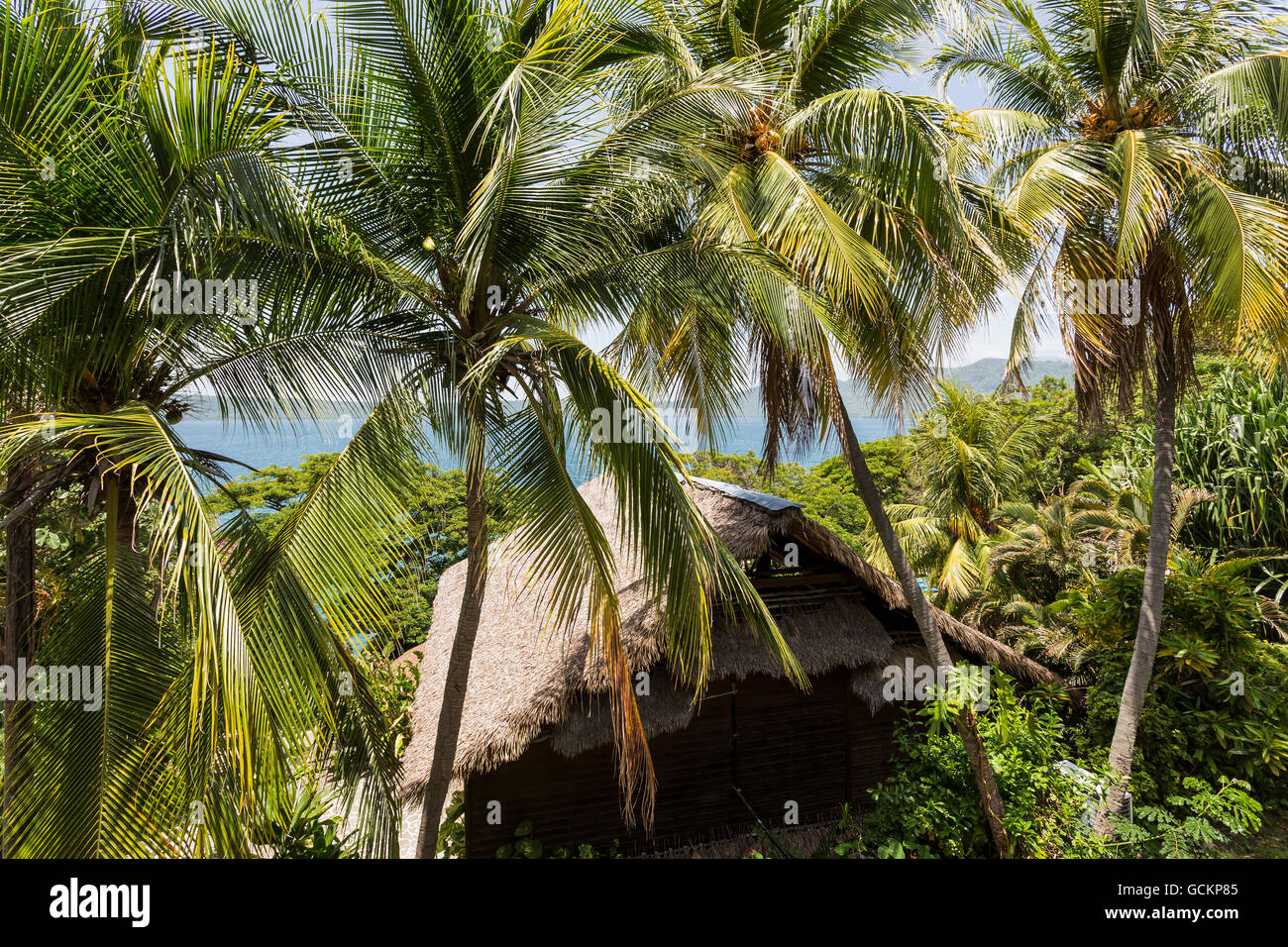 Laguna di Apoyo, Nicaragua - Giugno 2016. Le palme, acqua e bungalows a Selva Azul Resort Foto Stock