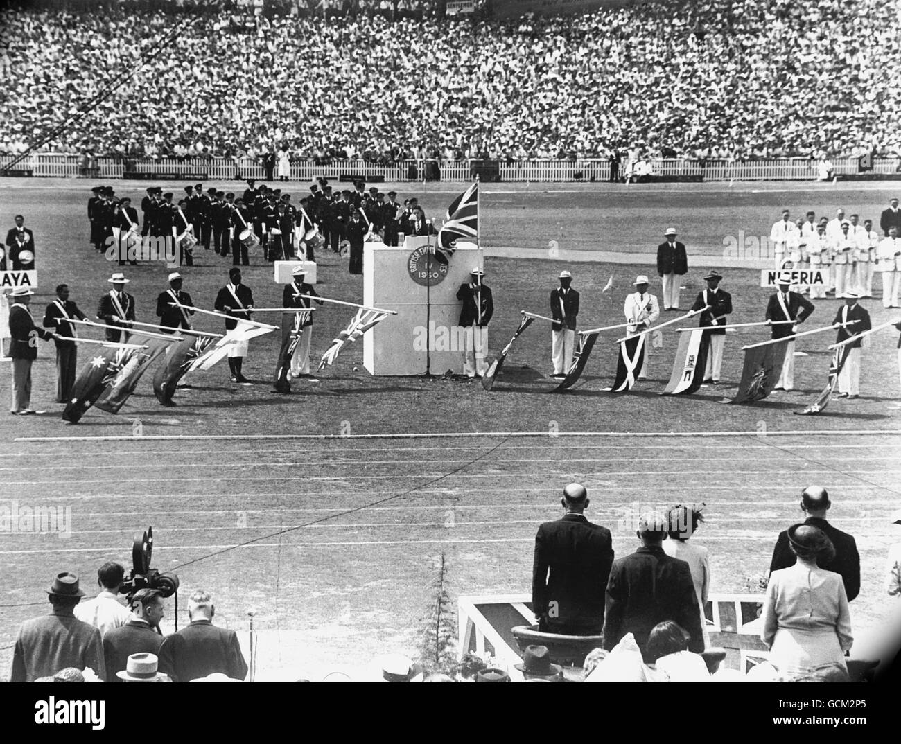 Quarto British Empire Games - cerimonia di apertura - Eden Park, Auckland. Stan Lay, capitano della squadra neozelandese che prende il giuramento di dilettantismo con le bandiere dell'Impero abbassate. Foto Stock