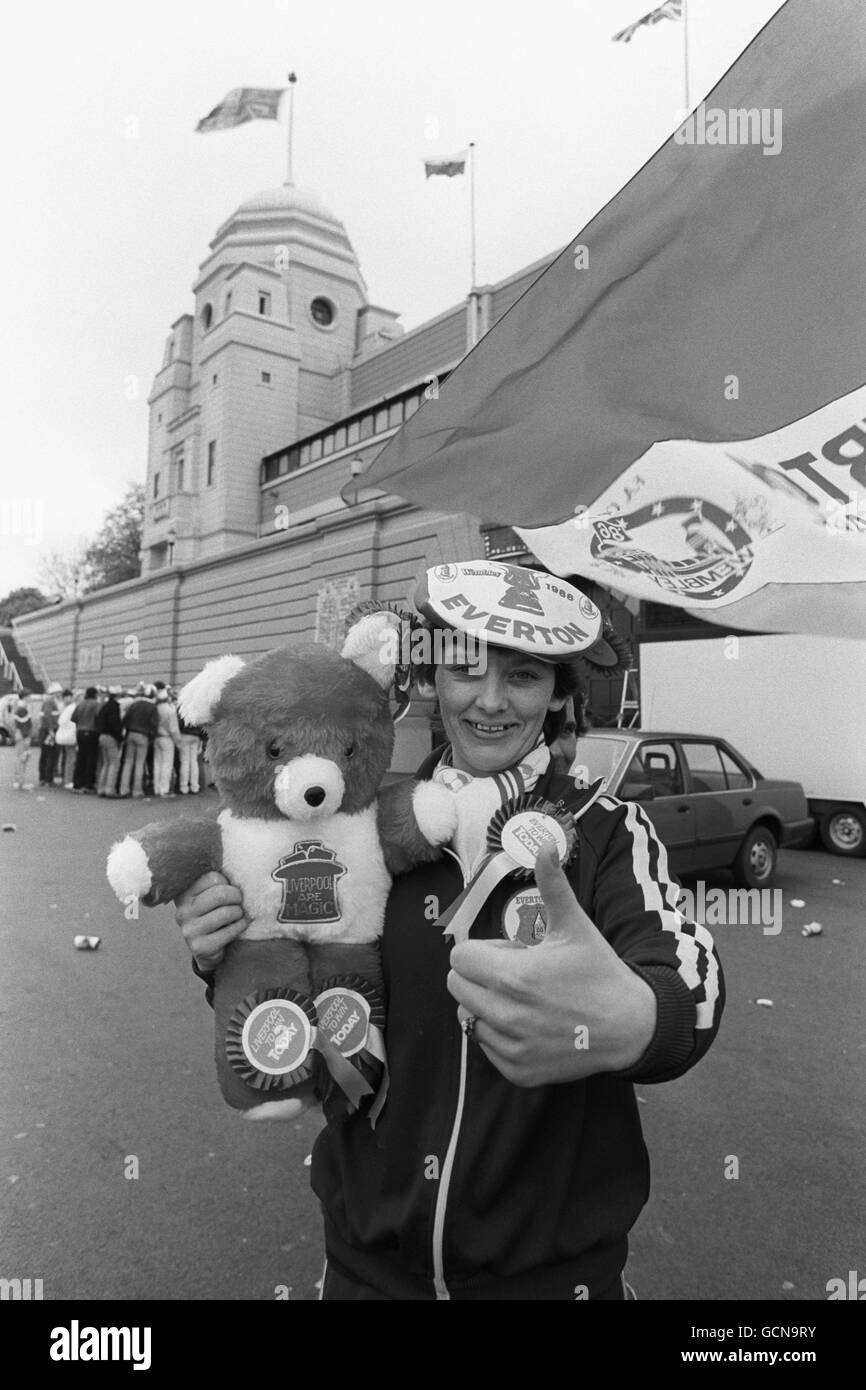 Al di fuori delle mura del Wembley Stadium, la fan di Everton Debbie Taylor dà i pollici per la sua squadra, nonostante il suo orsacchiotto sia un sostenitore di Liverpool! Foto Stock