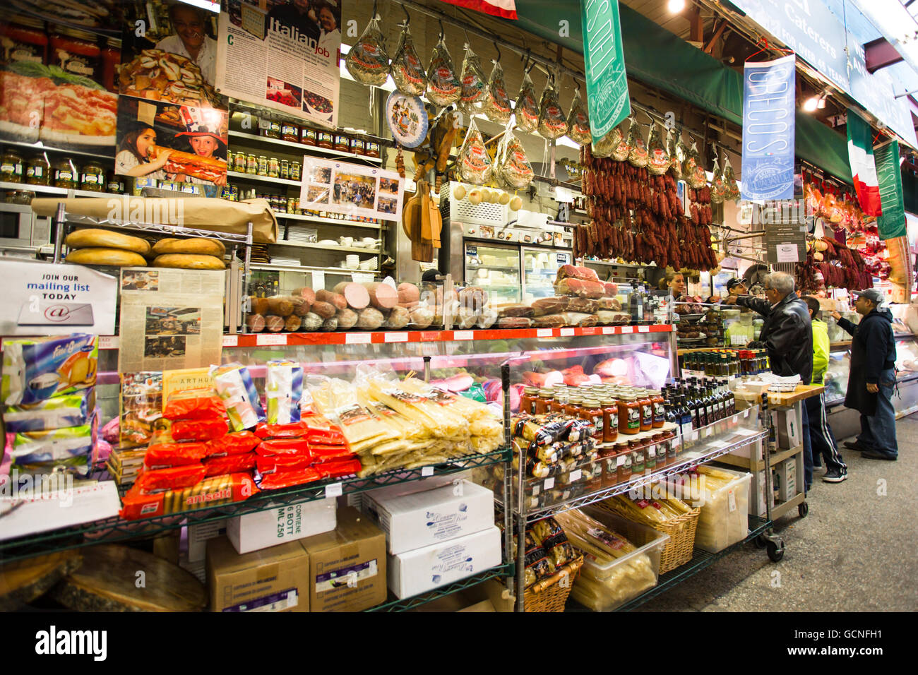 Contatore con lavoratore a deli italiana nel mercato specializzato in Little Italy, Arthur Avenue nel Bronx. Foto Stock