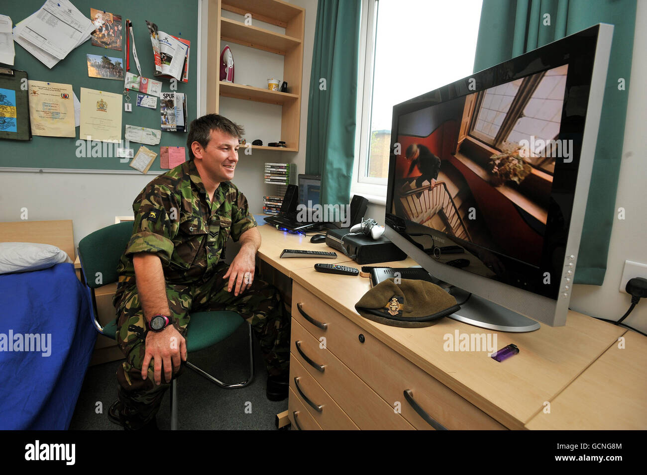 Il corporale Mark Walsh del reggimento reale della principessa del Galles, guarda la TV mentre si siede nella sua nuova sistemazione in camera singola, presso la Woolwich Barracks recentemente ristrutturata nel sud-est di Londra. Foto Stock