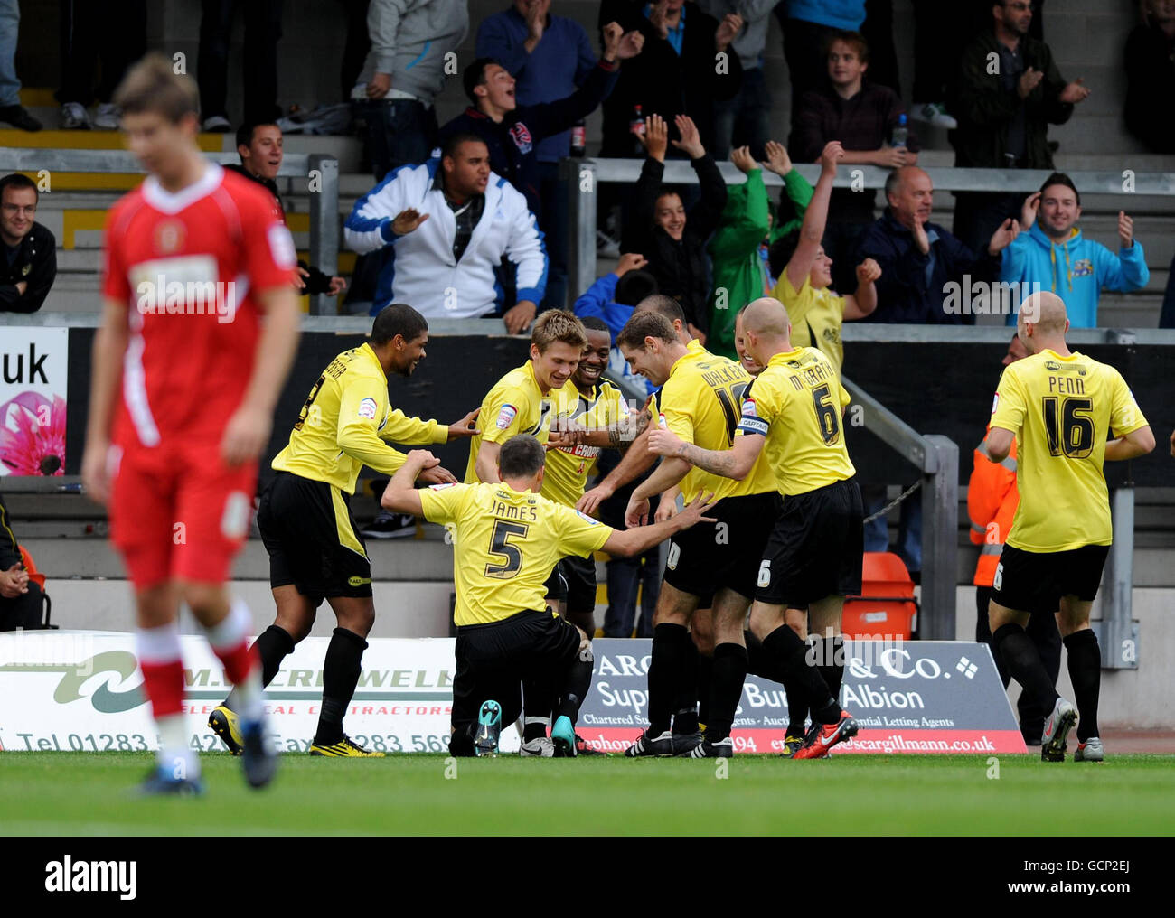 Jacques Maghoma di Burton Albion (centro indietro) festeggia con i suoi compagni di squadra dopo aver segnato l'obiettivo di apertura del gioco durante la partita di Npower Football League 2 allo Stadio Pirelli, Burton on Trent. Foto Stock