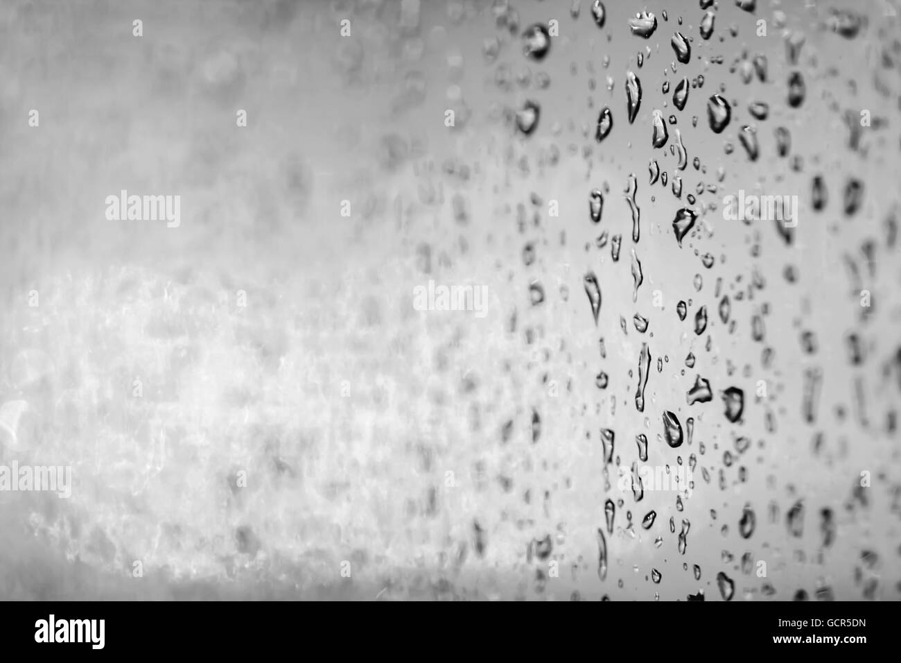 Primo piano di una pioggia o di gocce di acqua su un vetro di un finestrino Foto Stock