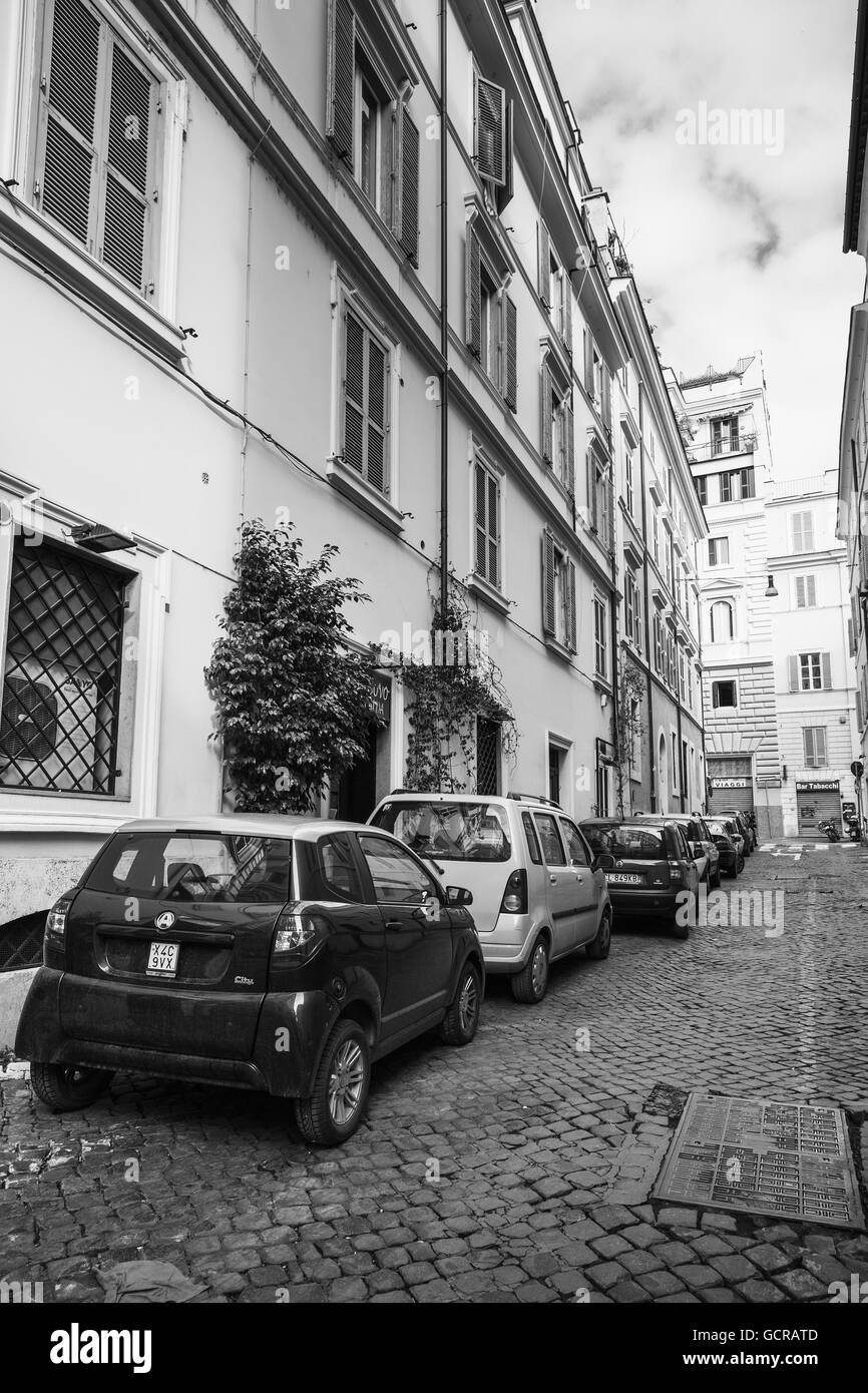 Roma, Italia - 13 Febbraio 2016: strada ordinaria di Roma vecchia con le automobili parcheggiate su una banchina, in bianco e nero Foto Stock