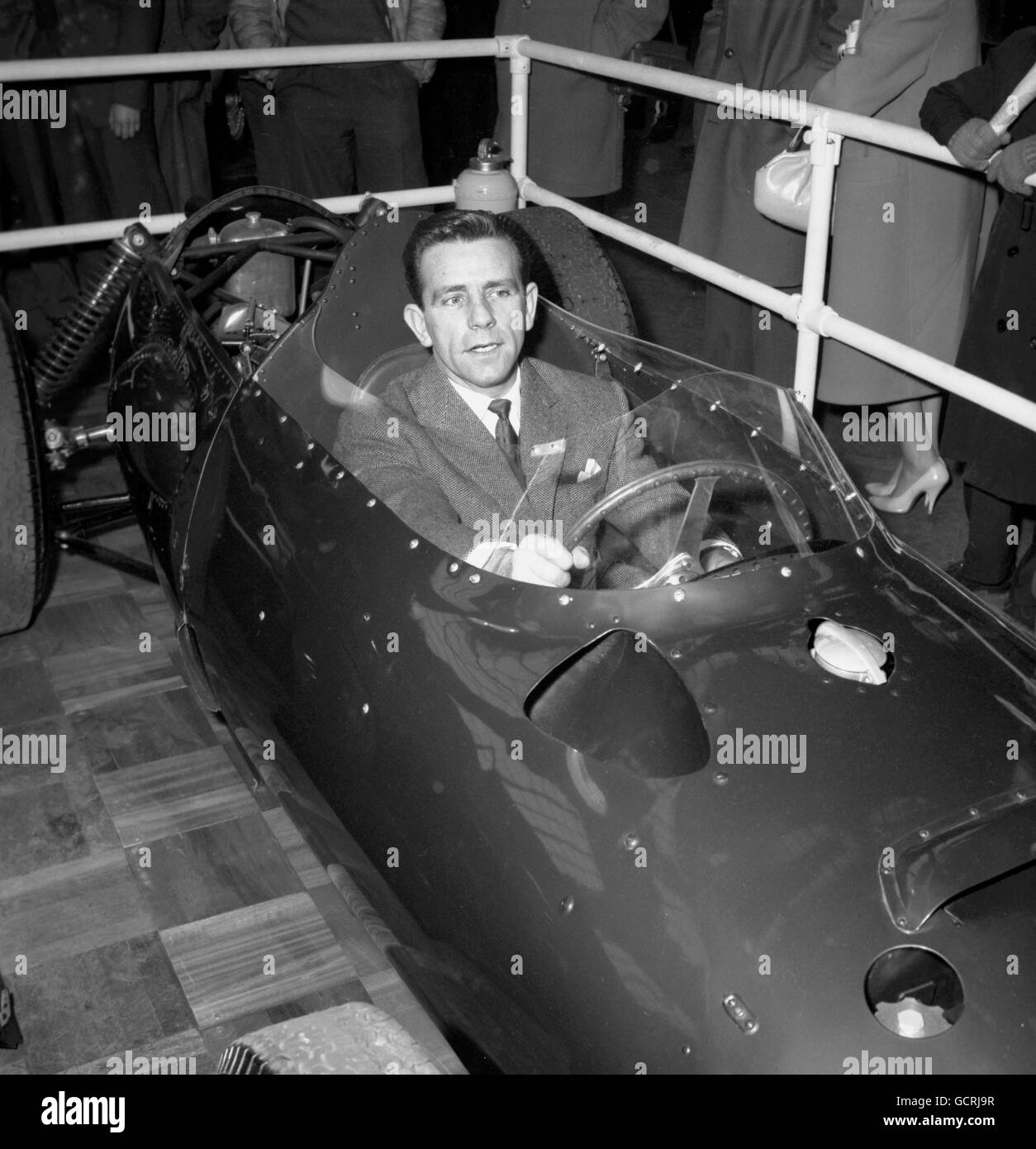 Il comico Norman Wisdom ha provato il posto di guida di una BRM durante la sua visita odierna al secondo Salone annuale delle auto da corsa presso i Royal Horticultural Halls di Westminster, Londra. Foto Stock