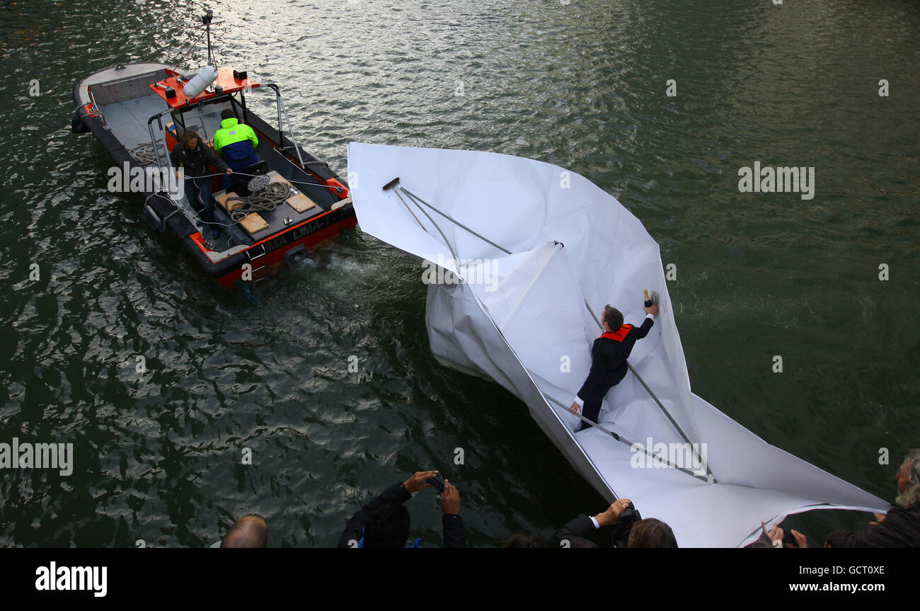 L'artista tedesco, Frank Bolter, galleggia un'installazione di una barca di carta chiamata alla fine del mondo. Una barca di carta origami che è stata piegata a Canary Wharf, Londra, poi navigato sul vicino Tamigi come parte della mostra d'arte biennale Drift10. Foto Stock