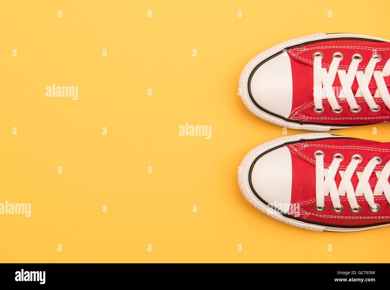 Sneakers rosso su sfondo giallo Foto Stock