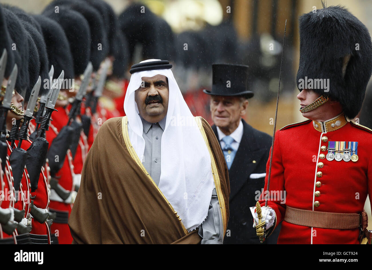 L'Emiro di Qatar Sheik Hamad bin Khalifa al-Thani, ispeziona la guardia d'onore nei giardini del Castello di Windsor Foto Stock
