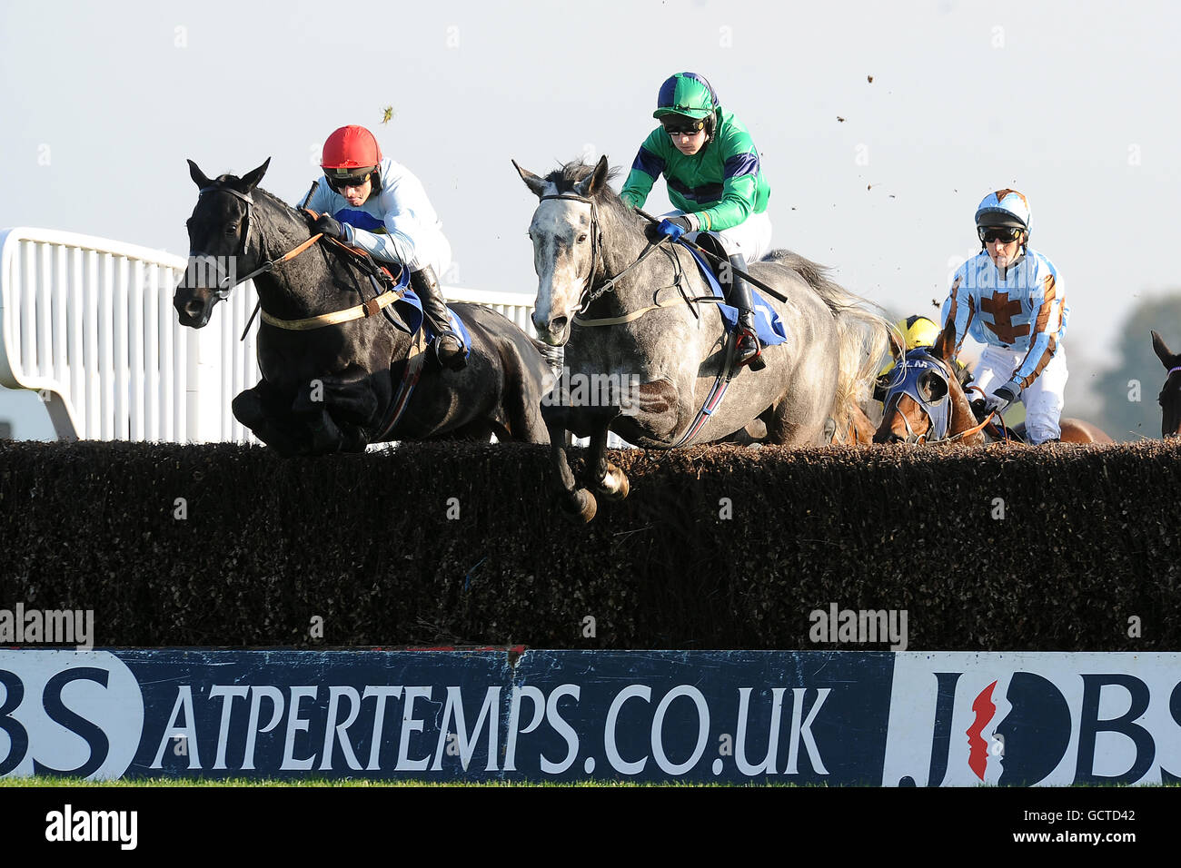 Jockey Charlie Poste su Solitary Palm (c) conduce da Leighton Aspell su Alteranthela (l) durante il London Irish Big 5 Inseguimento handicap dei novizi Foto Stock