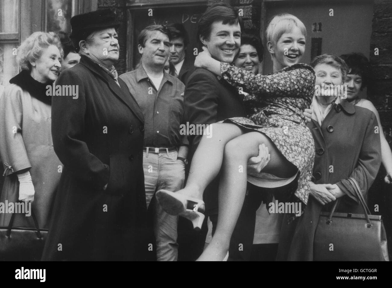 Dennis Tanner di Coronation Street (interpretato da Philip Lowry), porta a casa la sua sposa Jenny Sutton (Mitzi Rogers) come altri residenti, tra cui Ena Sharples (Violet Carson) guardare sopra. Foto Stock