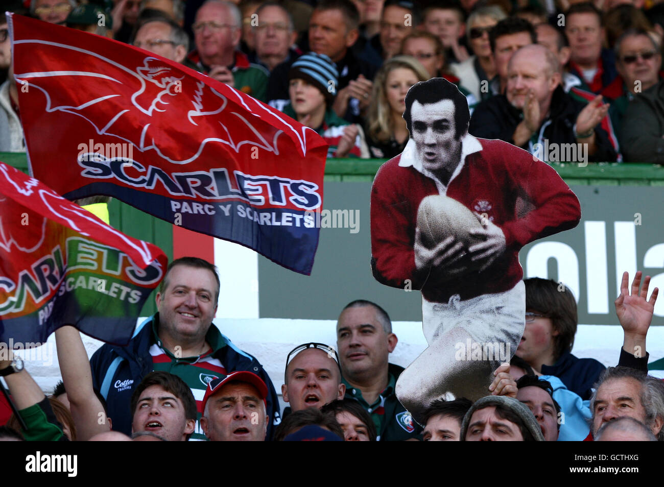 Llanelli Scarlets tifosi mostrare il loro sostegno negli stand come Presentano un taglio di cartone di Llanelli ex e Galles Fly mezzo Phil Bennett Foto Stock