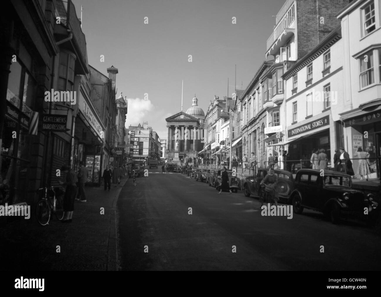 Scena di strada a Penzance, che mostra il mercato Hall alla fine della strada con la statua di Humphrey Davy di fronte. Foto Stock