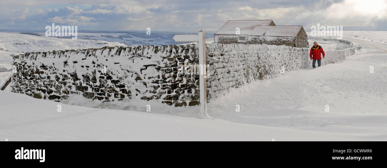 Un uomo cammina attraverso la neve profonda vicino a Castleton, North Yorkshire. Foto Stock