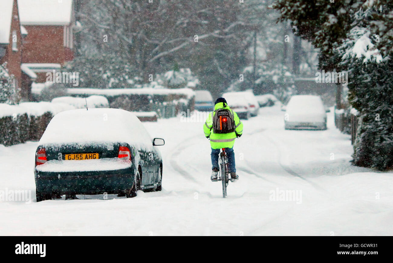 Un uomo in bicicletta per lavorare vicino ad Ashford, Kent, mentre il maltempo continua nel sud-est. Foto Stock