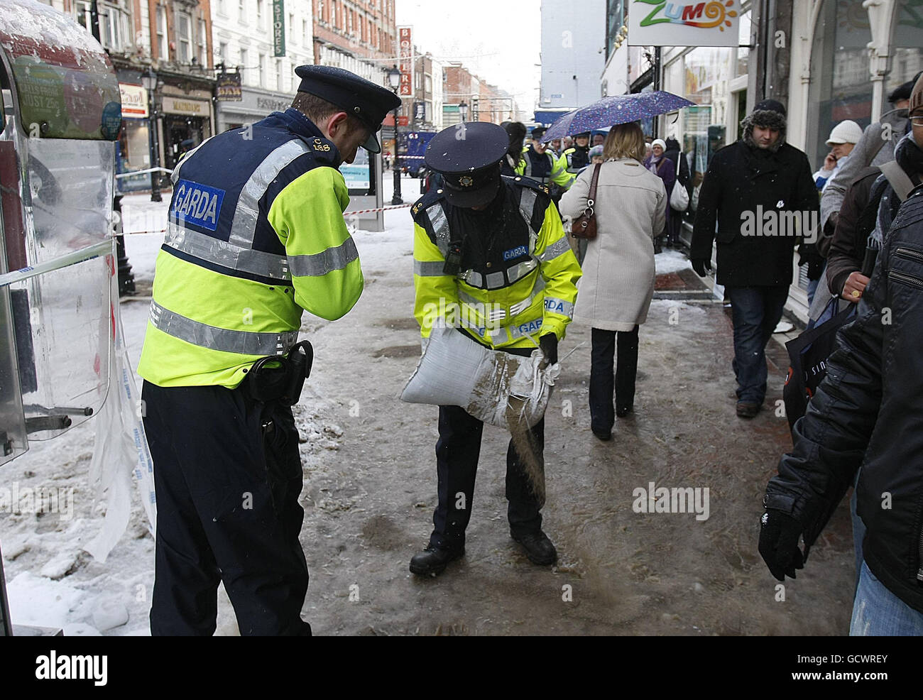 Gardai oggi diffonde sale sul sentiero nel centro di Dublino per aiutare a evitare che le persone scivolino mentre il maltempo continua. Foto Stock