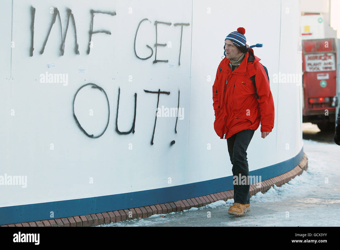 Bilancio irlandese. Un uomo cammina davanti a graffiti freschi contro il Bailout FMI mentre l'Irlanda si brace per il bilancio di martedì. Foto Stock