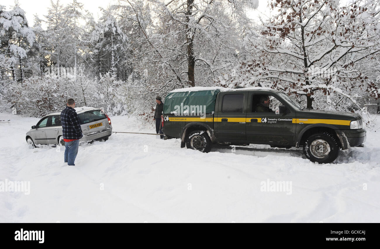 I lavoratori della commissione forestale aiutano un conducente bloccato nella neve in un parcheggio a Dalby Forest, North Yorkshire, come si prevede più nevicate lungo la costa orientale del Regno Unito. Foto Stock