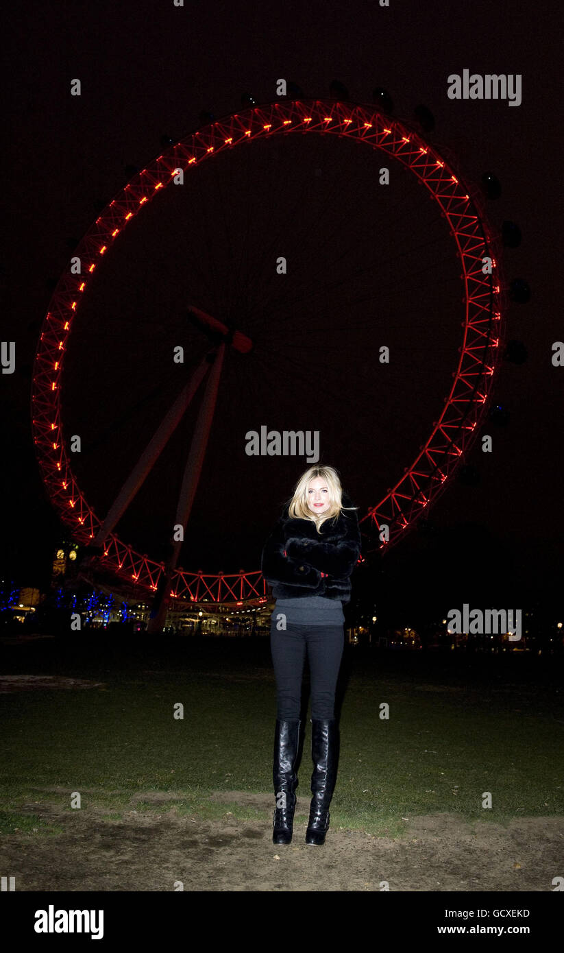 (ROSSO) il sostenitore Sienna Miller si trova di fronte al London Eye, illuminato di rosso per evidenziare l'obiettivo raggiungibile di una generazione di bambini nati liberi da HIV entro il 2015 nella Giornata Mondiale dell'Aids. Foto Stock