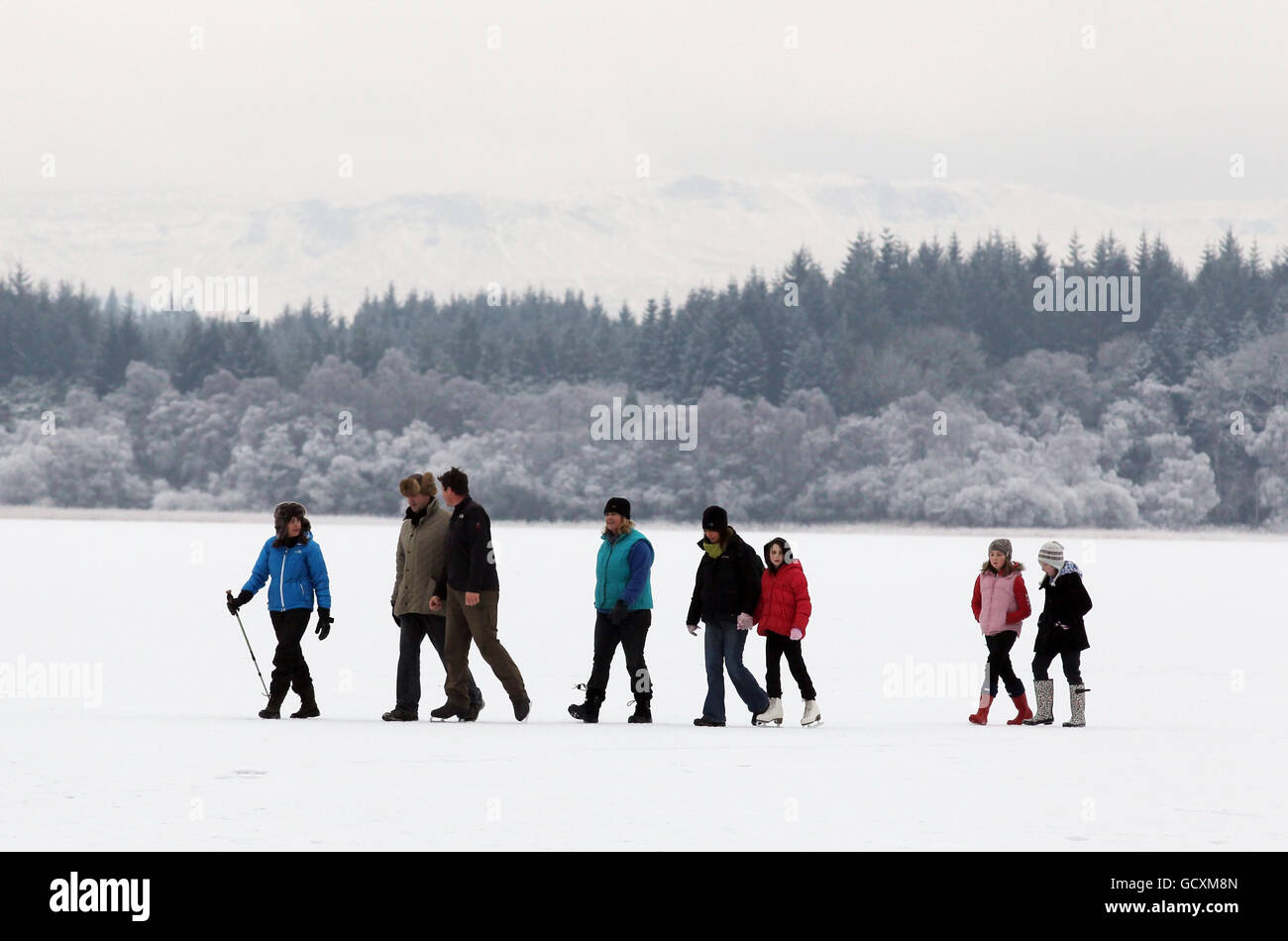 Tempo invernale 26 dicembre. Una famiglia va per una passeggiata su un lago ghiacciato di Menteith, come il tempo freddo continua. Foto Stock