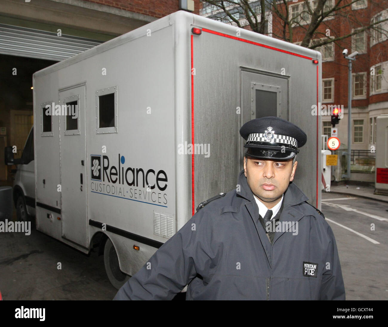 Un poliziotto si trova di fronte a un furgone che si ritiene contenga Shrien Dewani quando arriva alla City of Westminster Magistrates' Court di Londra. Foto Stock