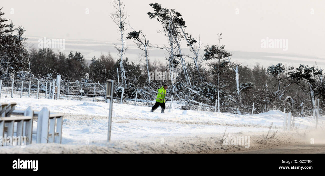 Un uomo cammina nelle North Yorkshire Moors, mentre il tempo invernale torna nel Regno Unito con neve, ghiaccio e forti venti che si snodano sulla costa orientale. Foto Stock