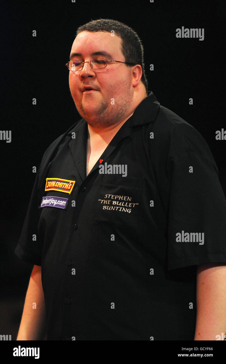 Stephen Bunting, in Inghilterra, si trova in una posizione sbattuta durante il suo gioco contro il Dean Winstanley dell'Inghilterra durante il BDO World Professional Darts Championship al Lakeside Complex, Surrey. Foto Stock