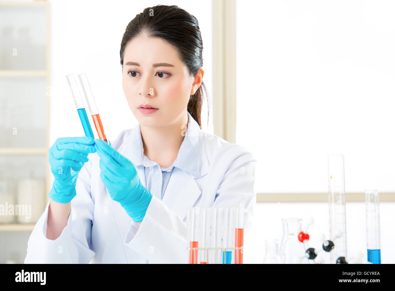 Femmina asiatica farmacia lavorando sulle sostanze chimiche in laboratorio Foto Stock