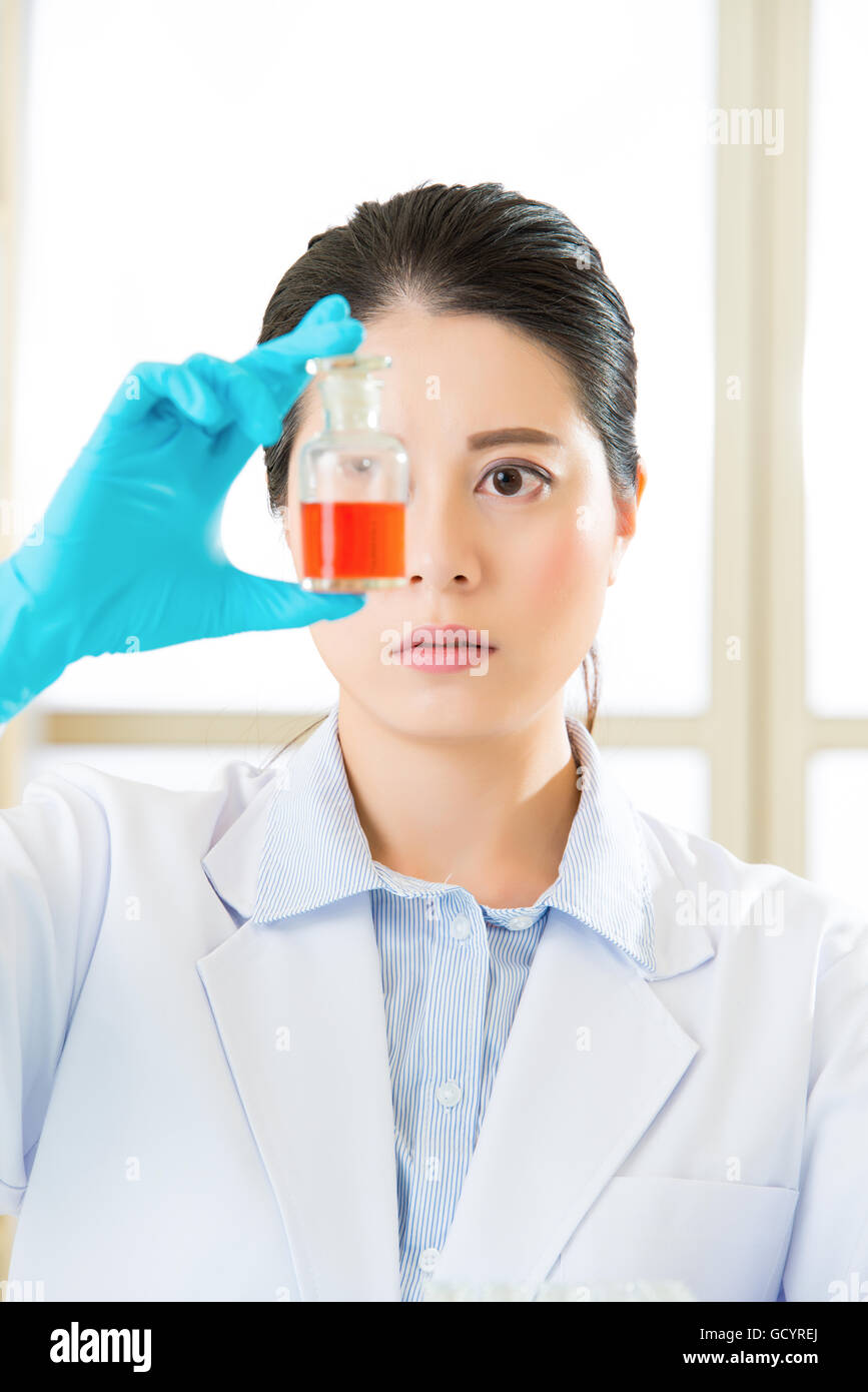 Donna scienziato sfidando le nuove frontiere mediche bottiglia con liquido rosso Foto Stock
