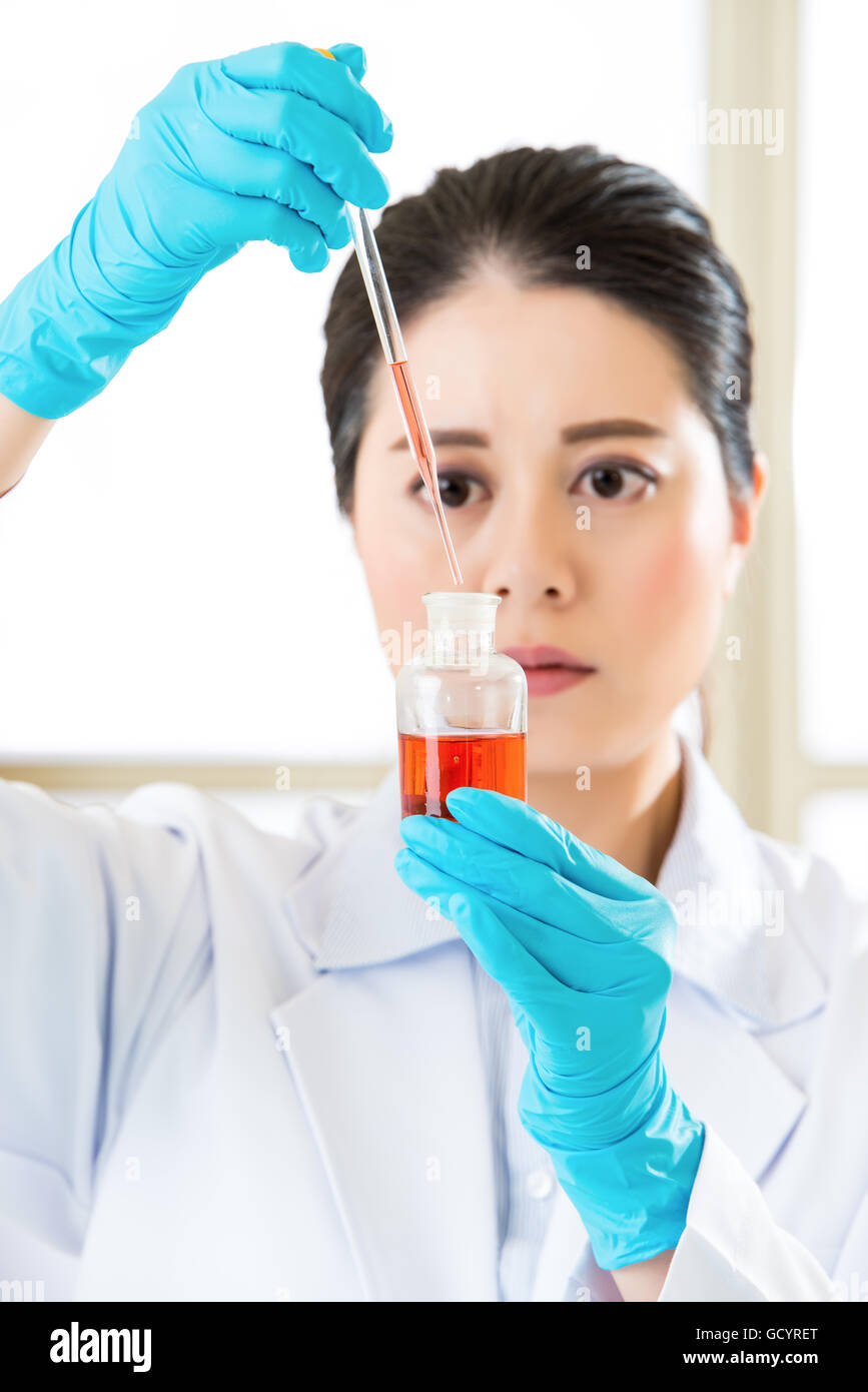 Asian donna scienziato di miscelazione di sostanze chimiche per uso medico in laboratorio Foto Stock