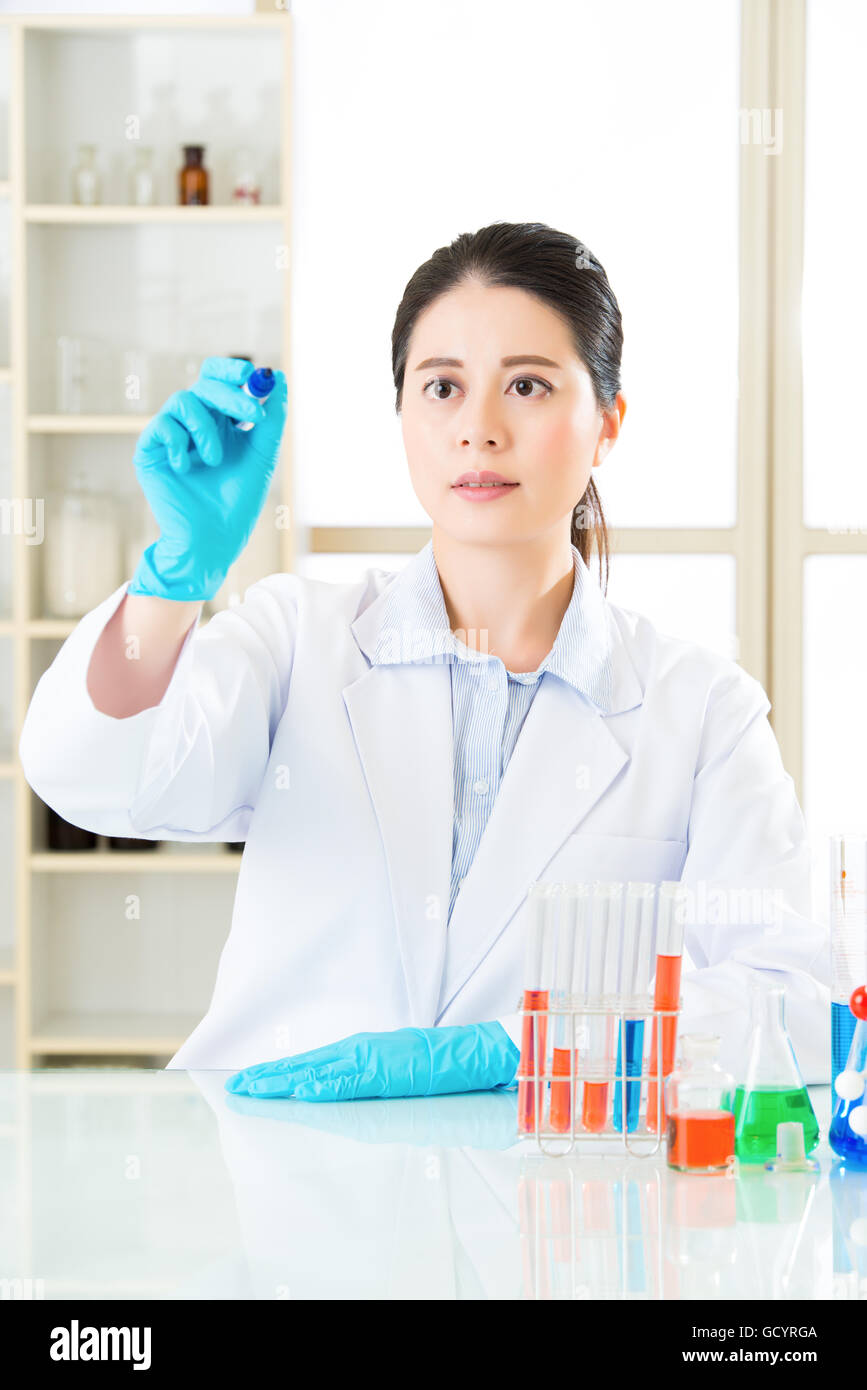 Asian donna scienziato determinato a perfezionare la formula idea di condivisione in laboratorio Foto Stock