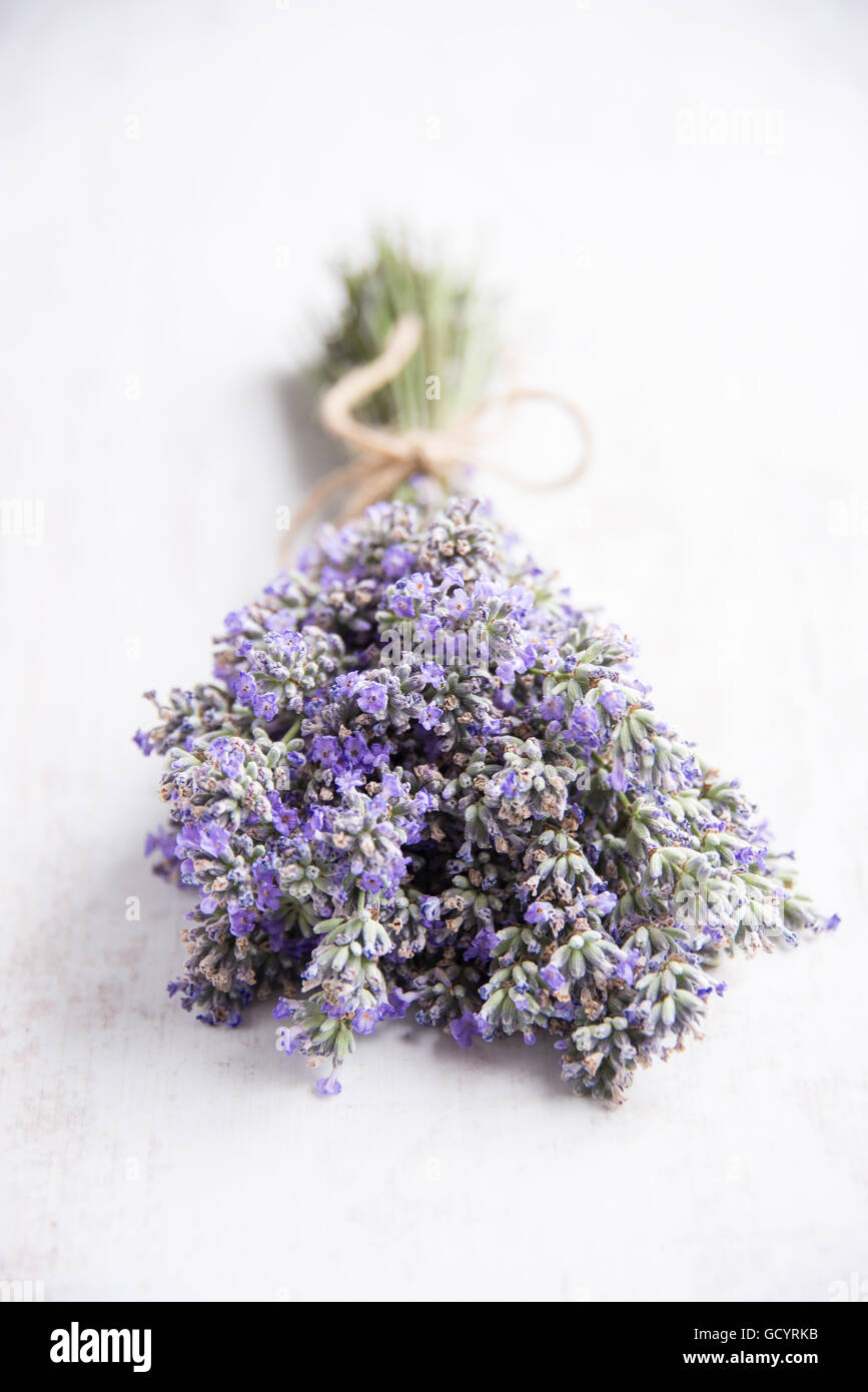 Chiusura del profumo di lavanda su un bianco sullo sfondo di legno. Foto Stock