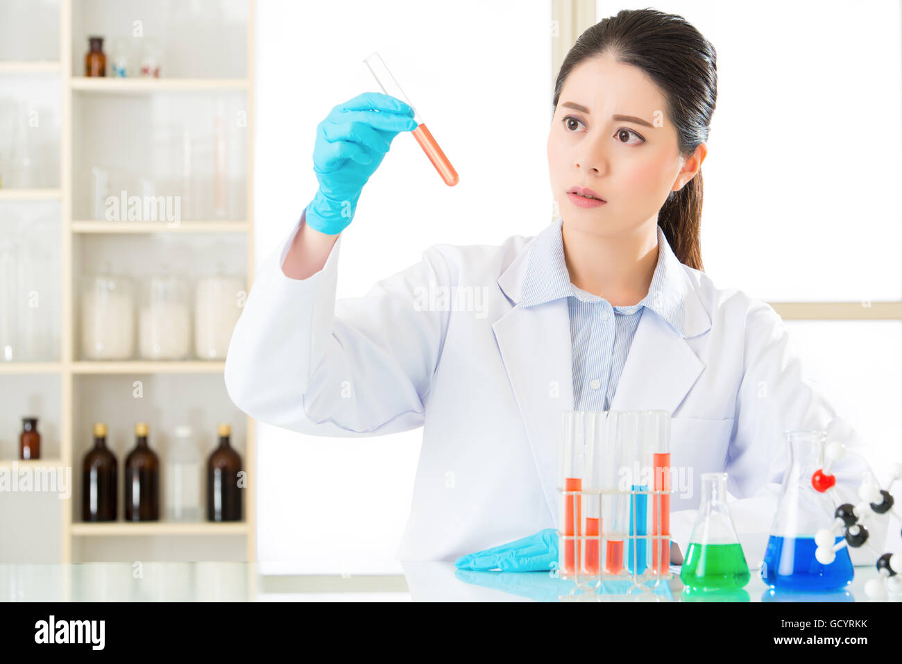 Asian femmina scienziato forense sfidando le nuove frontiere mediche sulle sostanze chimiche in laboratorio Foto Stock