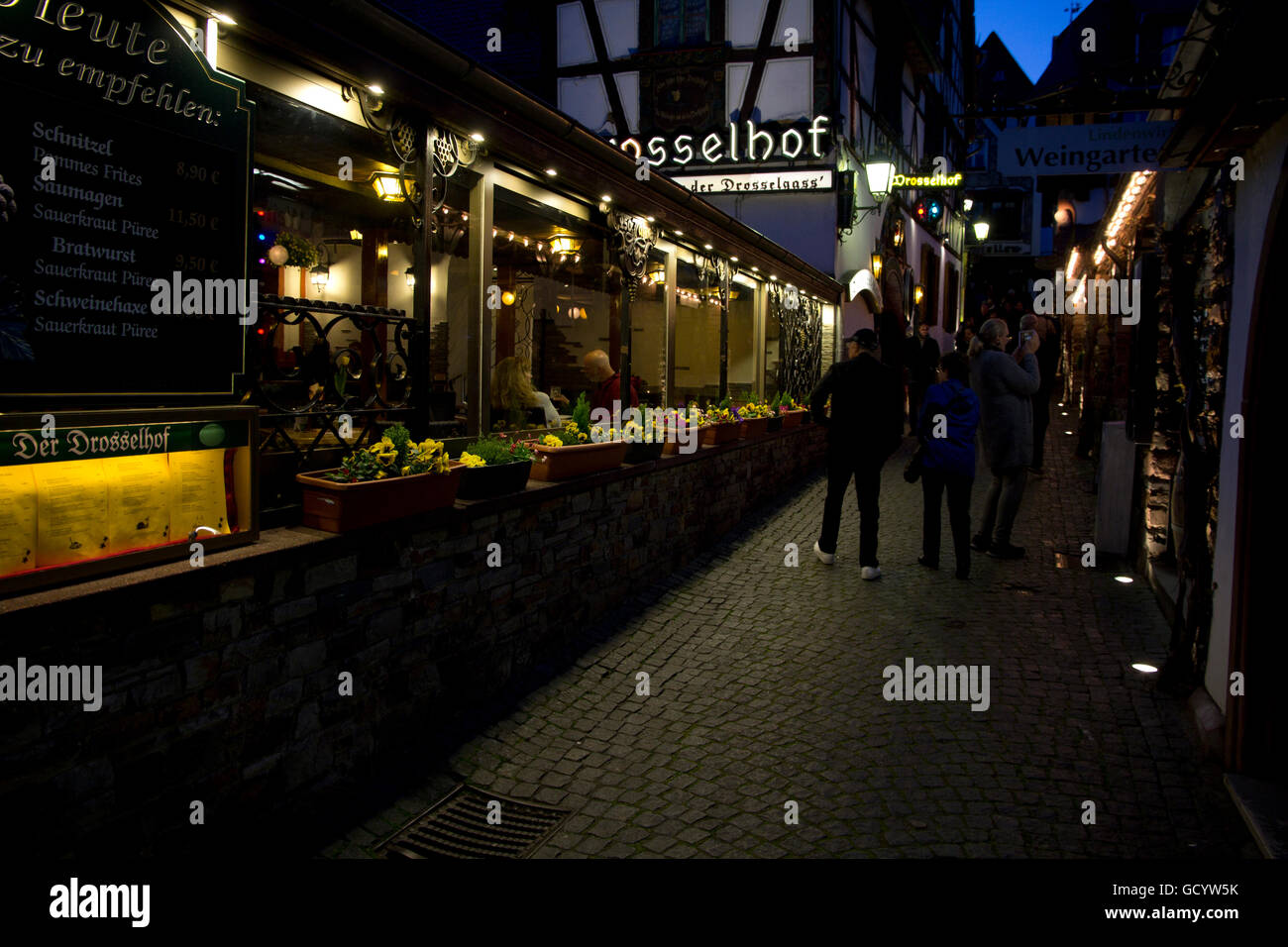 I visitatori di passeggiata il famoso e sempre popolari Drosselgasse, un medievale strada di ciottoli con wine bar, caffetterie, taverne e negozi. Foto Stock