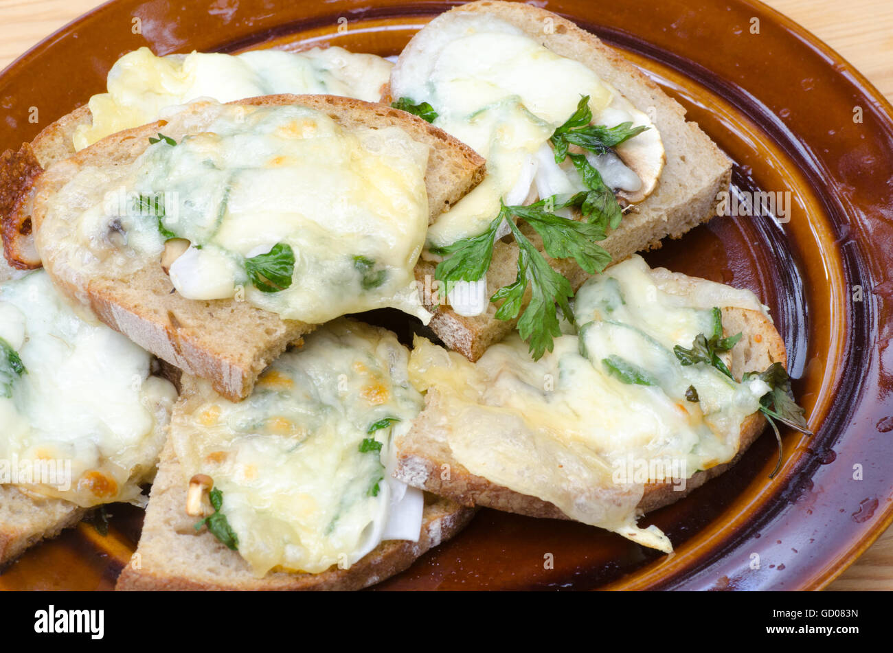 Pane grigliato con formaggio fuso e prezzemolo Foto Stock