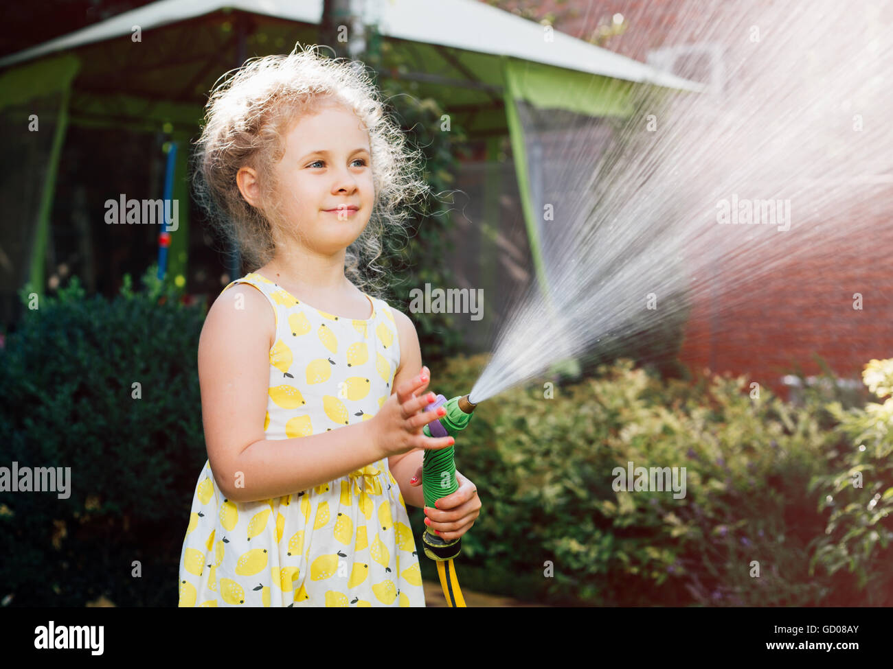 Bambina abbeveraggio l erba del giardino. Foto Stock