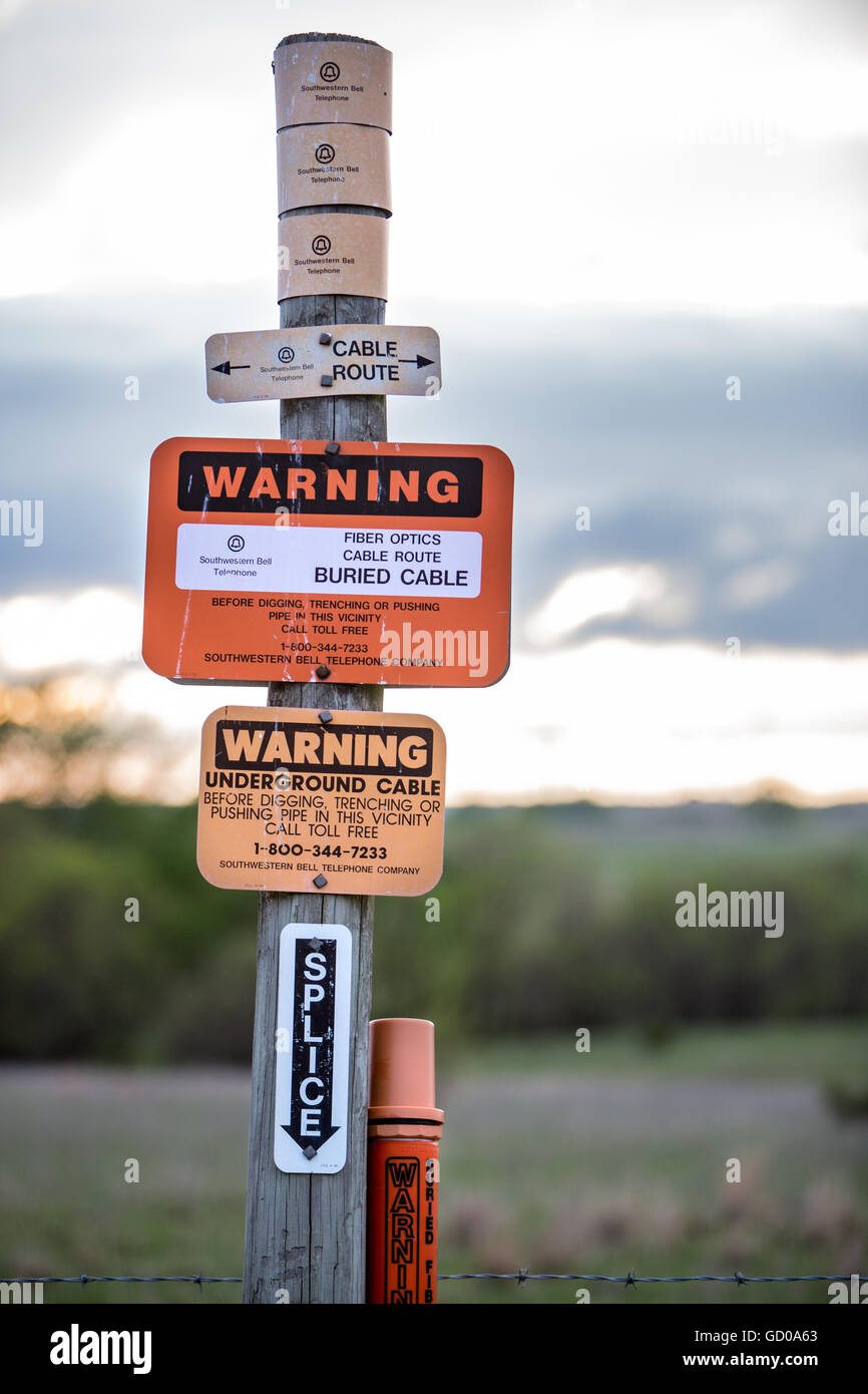 Segno che avvisa che il cavo a fibre ottiche è sepolta sotto. Foto Stock